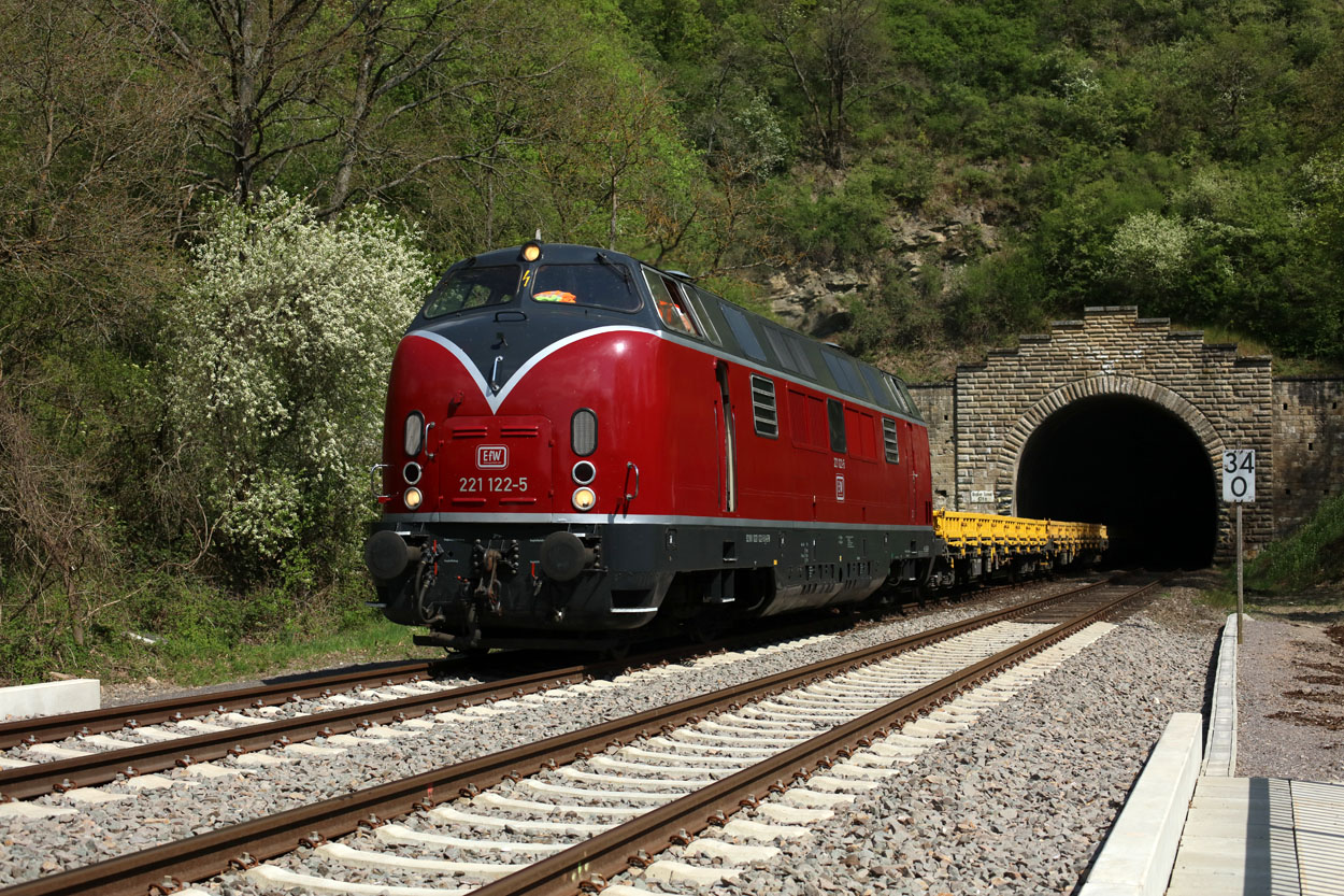DB Bahnbau used EfW 221 122 to transfer some empty flat cars from Koblenz-Luetzel to Saarbruecken, here seen leaving the tunnel at Staudernheim on 17 April 2020.