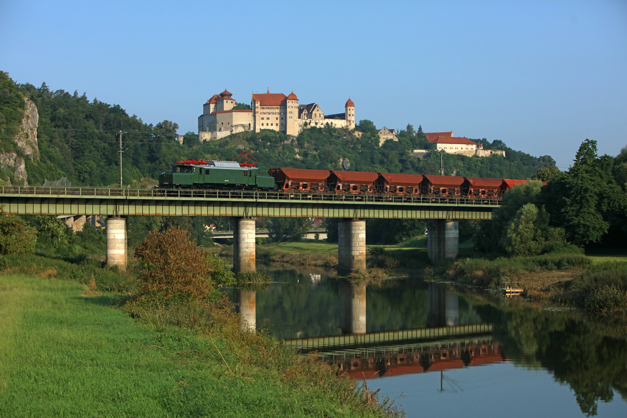 Bayerisches Eisenbahnmuseum 194 192 pulls ten open top hoppers type Fc as train 69303 (Nrdlingen - Donauwrth) across the Wrnitz River bridge in front of Harburg Castle in Harburg, Germany.